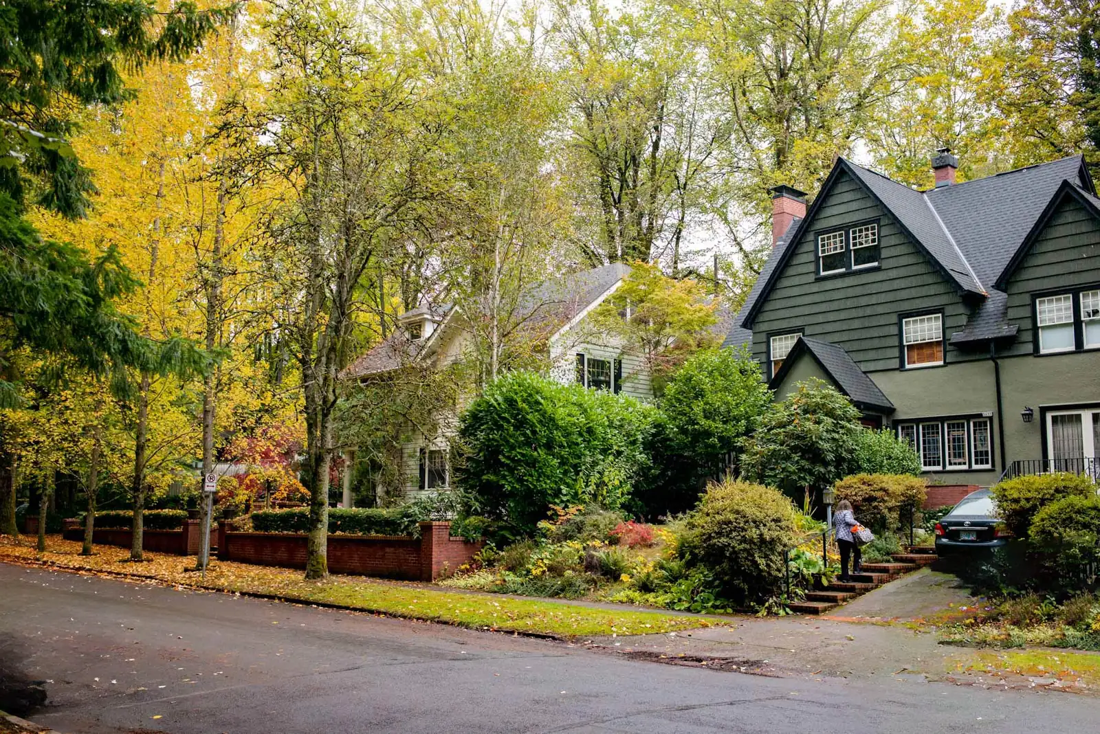 A Portland street in Laurelhurst under yellow October trees, a dark green house at the corner